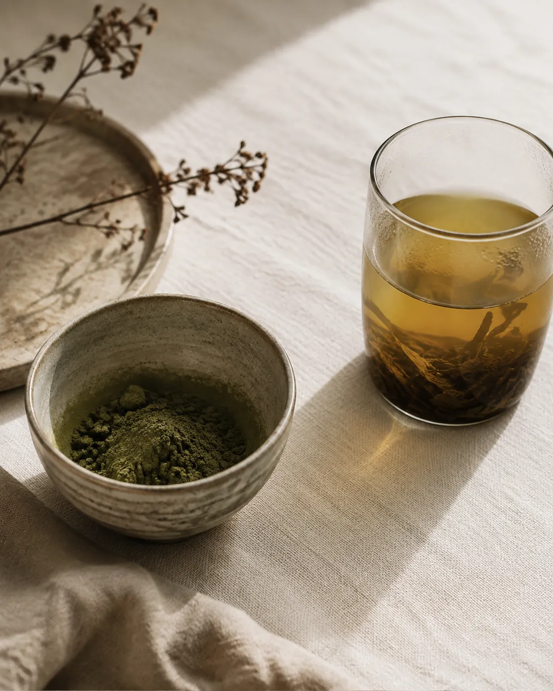 A bowl of dull olive matcha beside a cup of over-steeped green tea gone dark yellow