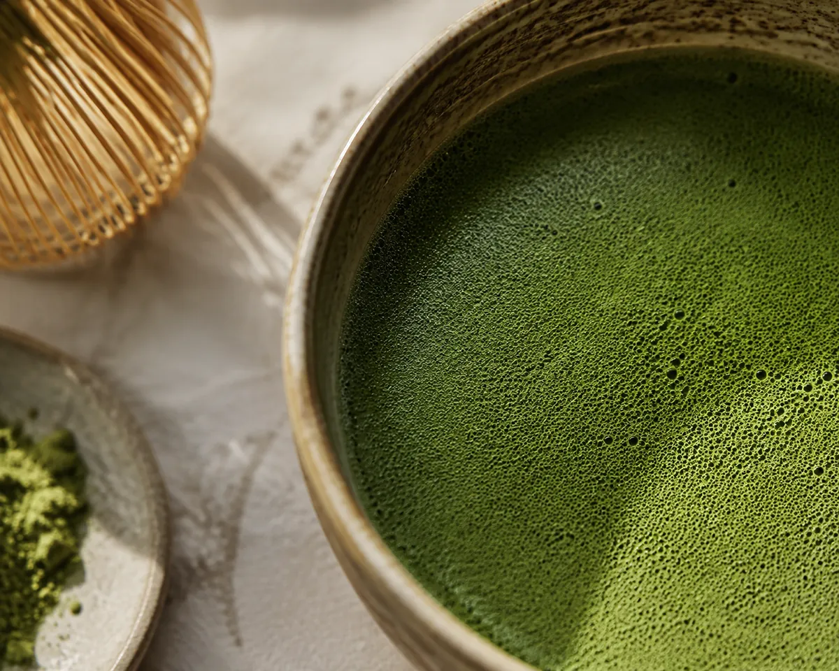 Extreme close view of the surface of whisked matcha showing a fine even bubble structure
